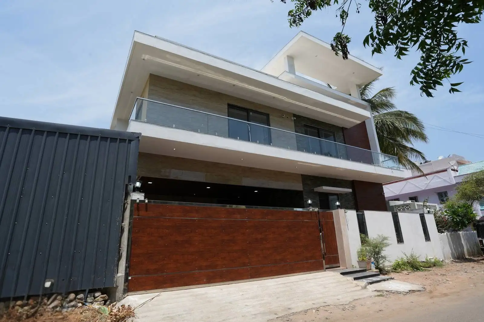 The flat roof, cantilevered balcony, and expansive windows define a refined design focused on simplicity, shade, and seamless indoor-outdoor flow.