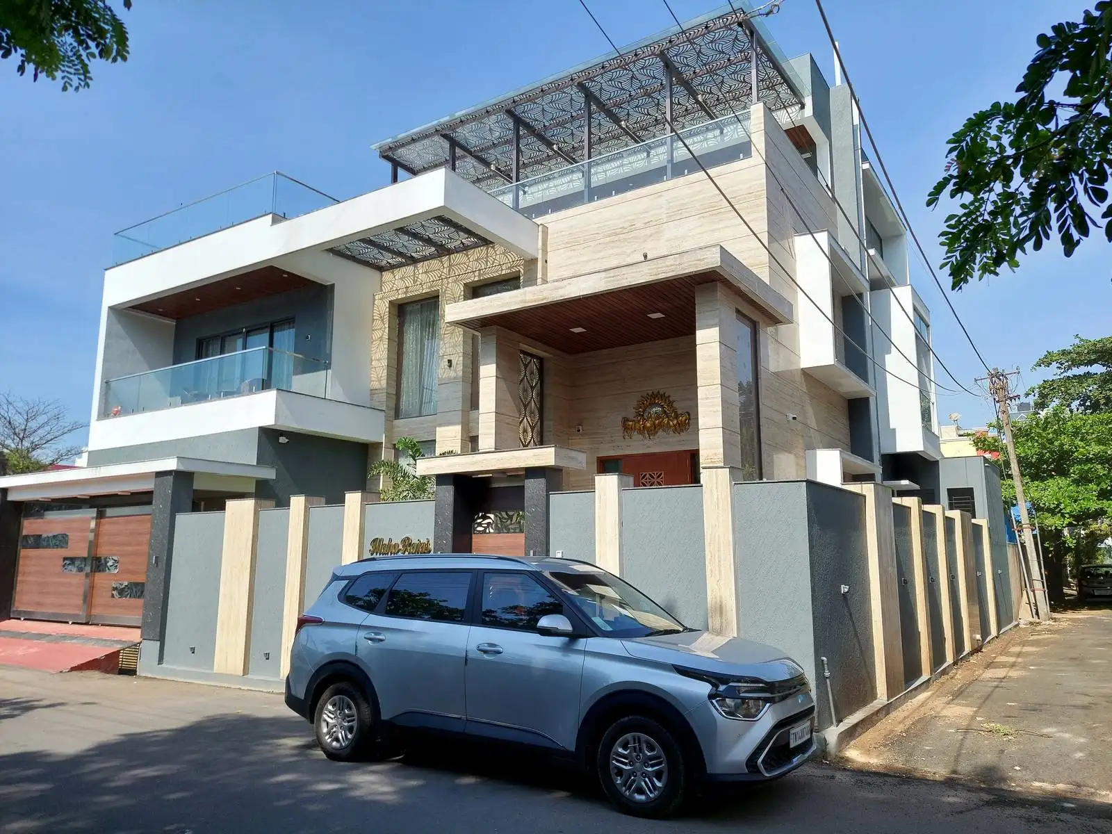 Glass railings on balconies enhance views and natural light, while the textured boundary wall ensures privacy and complements the building’s design.