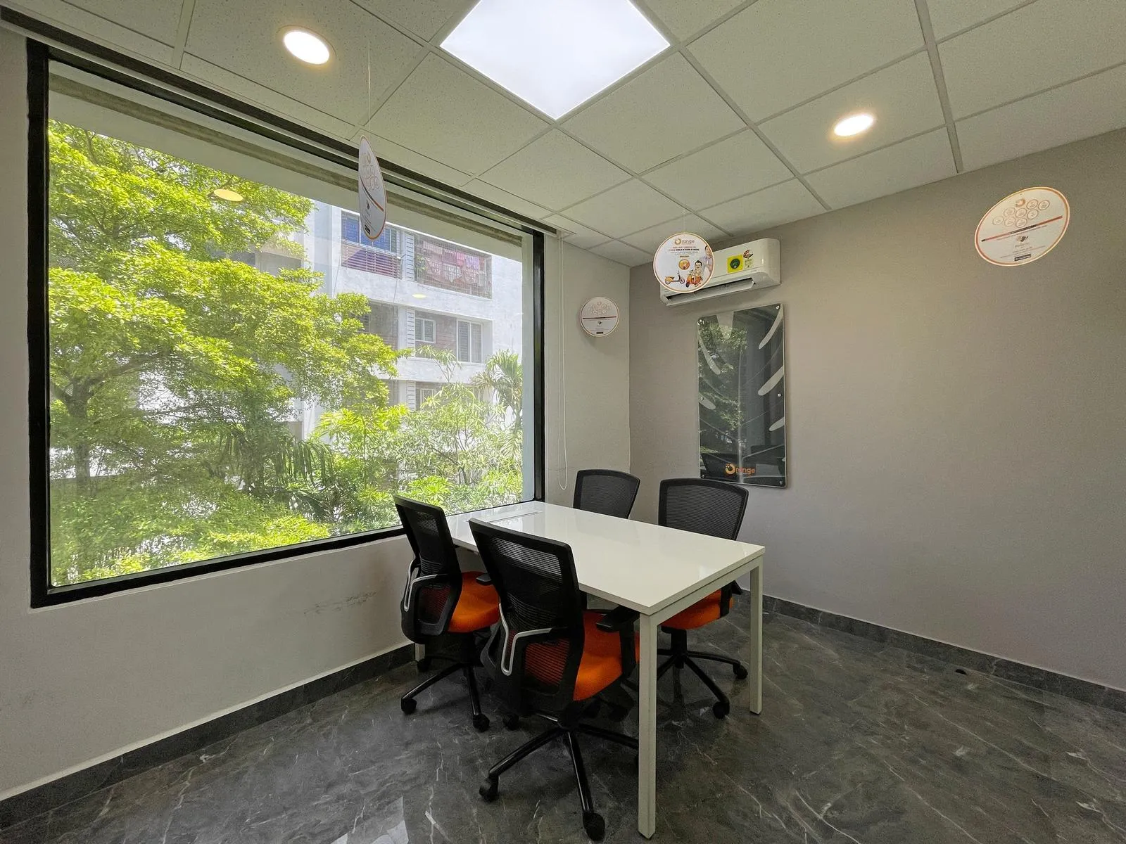 This modern four-seater Meeting Room 1 combines ergonomic furniture, floor-to-ceiling windows, and natural light to boost productivity and comfort. Premium finishes, marble-effect flooring, and recessed lighting create a sleek, professional workspace.