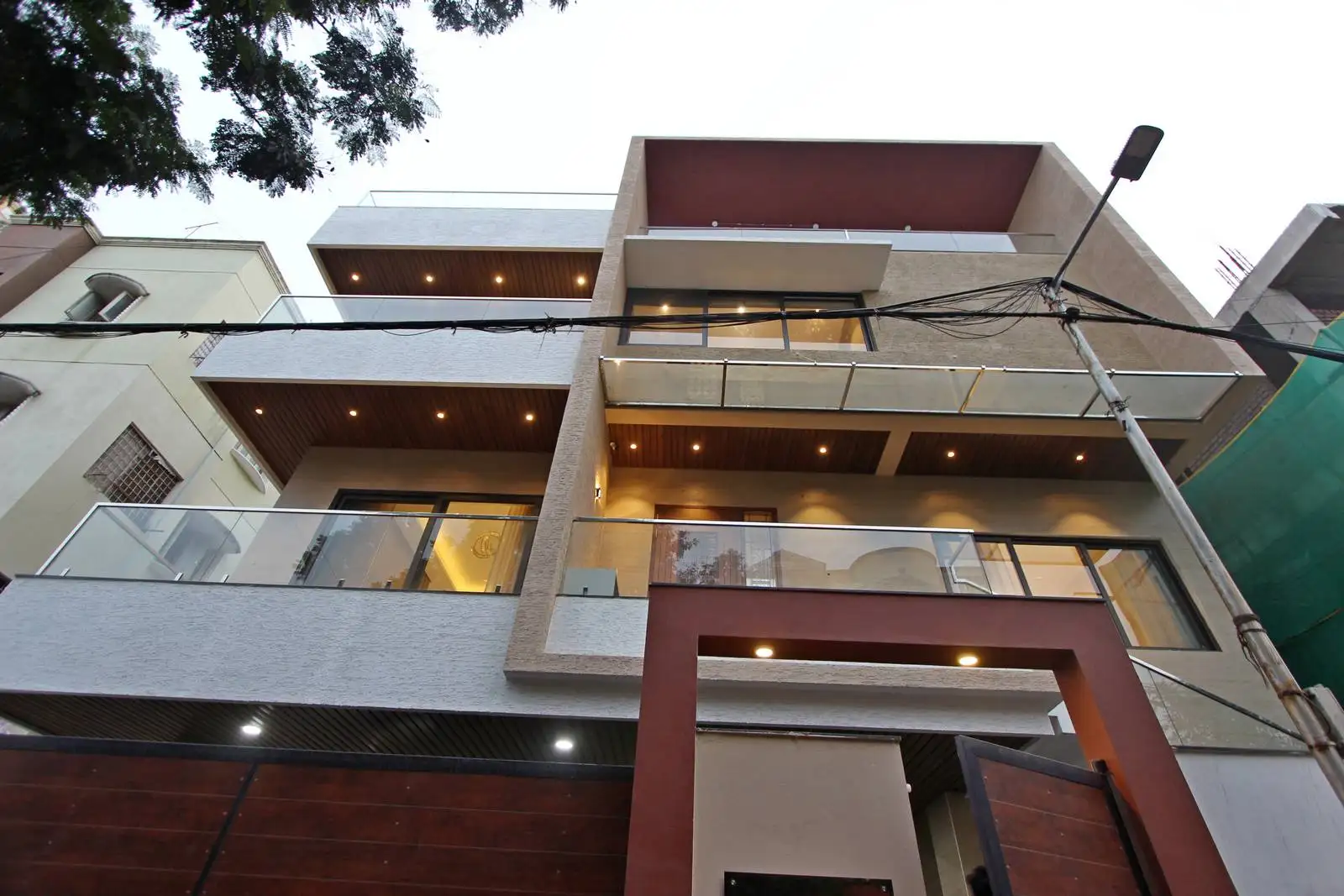 A bold, deep-toned entrance archway defines the entry and creates a strong arrival statement. Layered facade planes and integrated gate design add depth and cohesion to the property.
