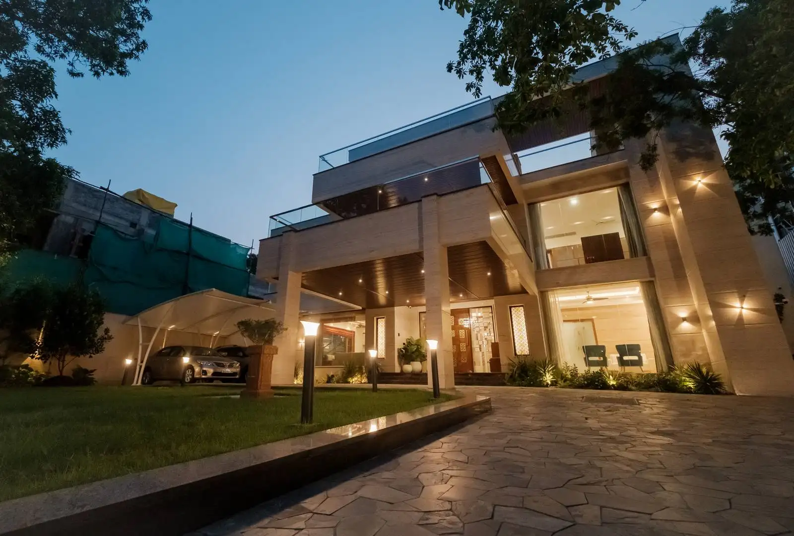 The layered massing with bold cantilevers creates a striking multi-level facade, offering covered outdoor spaces and a sculptural architectural entrance.