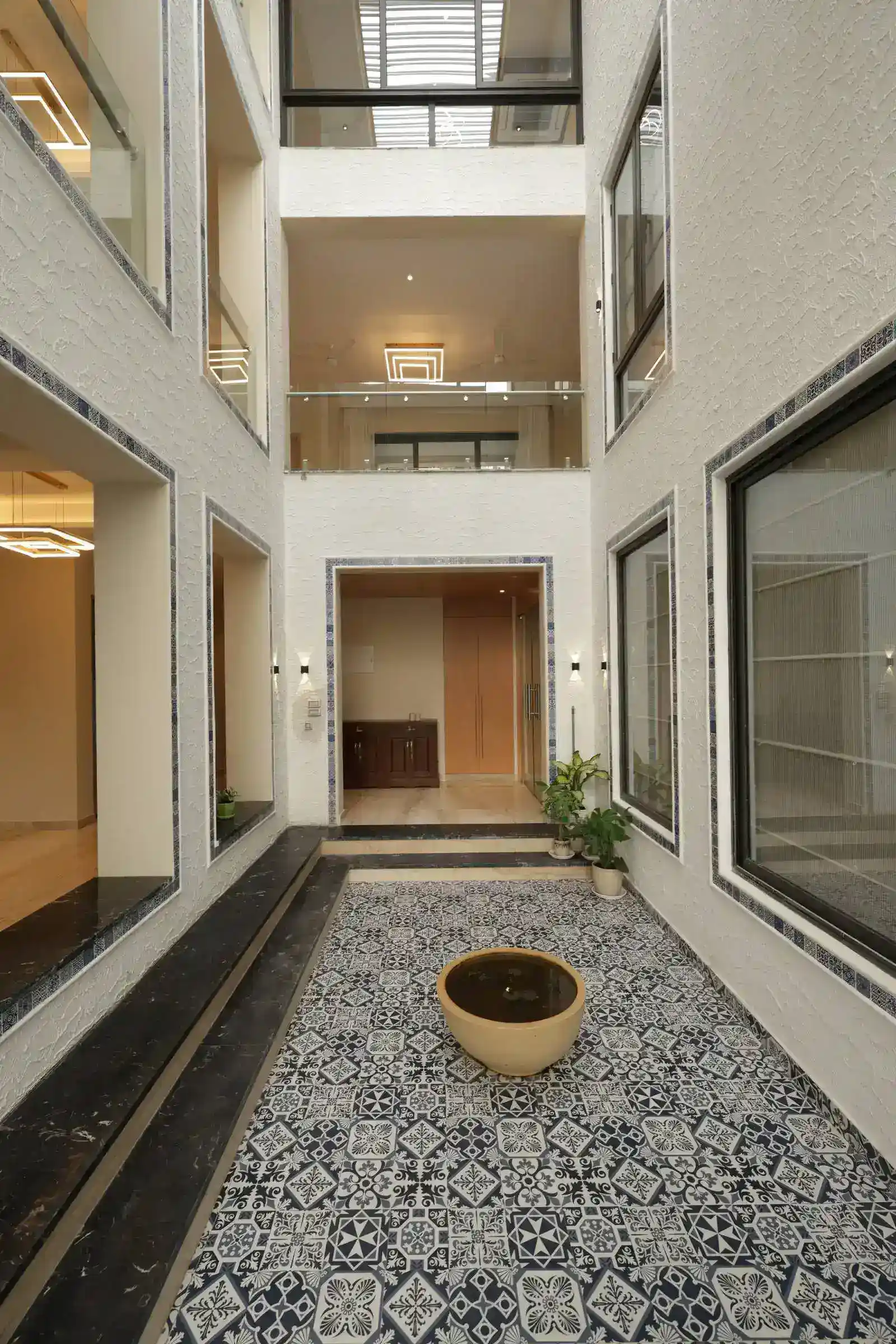 The courtyard is a vertically open atrium, surrounded by rooms on multiple floors, allowing natural light to penetrate deep into the building.
