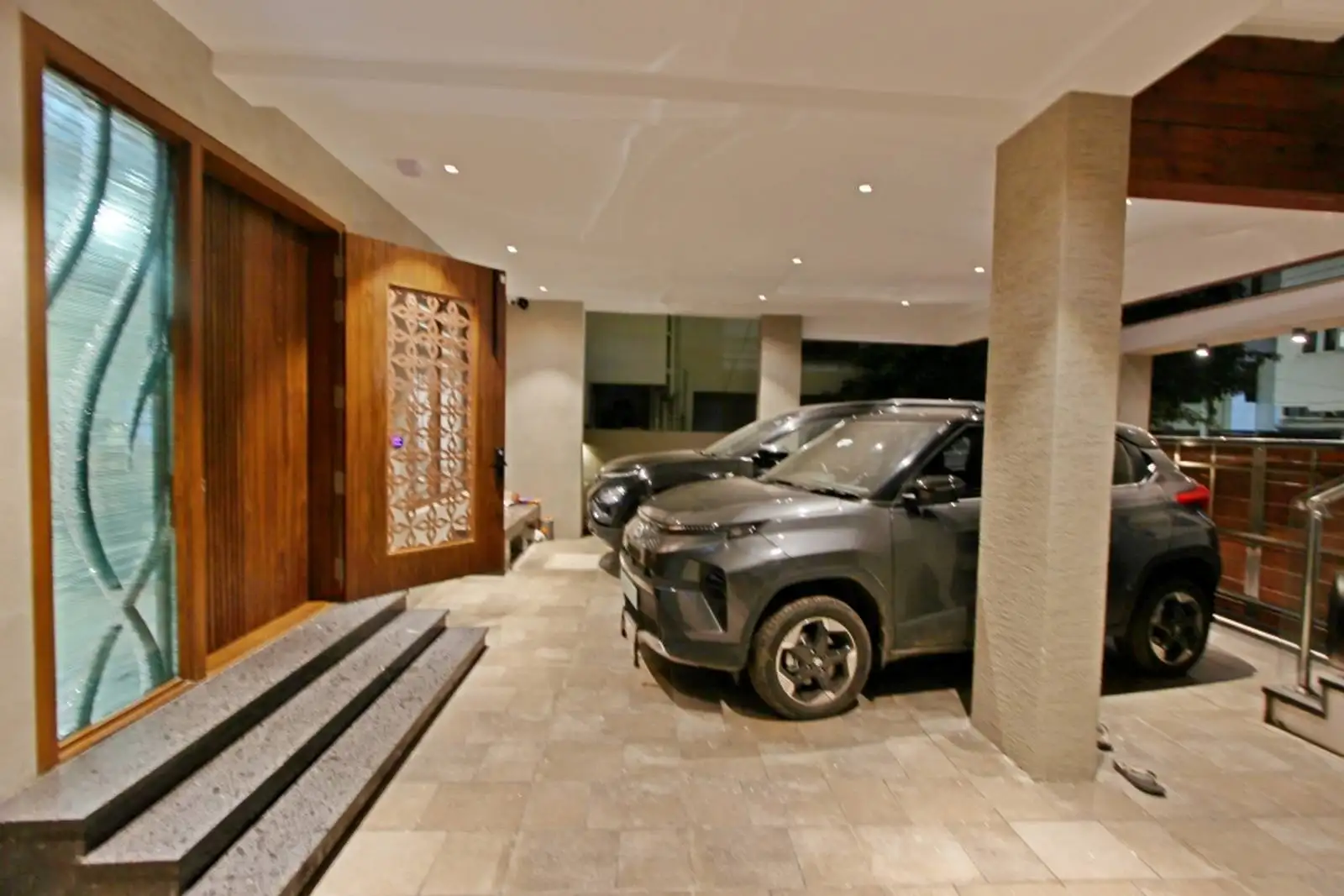 The area seamlessly integrates a covered car parking space with a welcoming lobby leading to the main entrance.