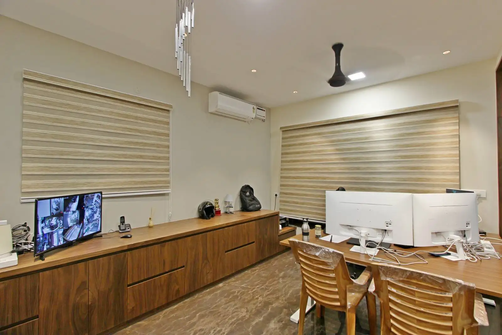 The room features large horizontal windows with neutral-toned blinds, offering adjustable natural light and privacy, complemented by a clutter-free, efficient layout for seamless circulation.
