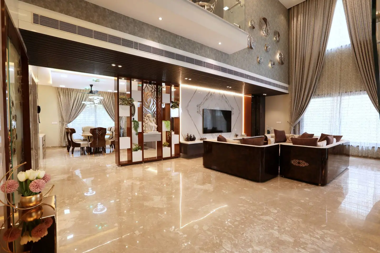 Open-plan living and dining areas are defined by a sleek partition with shelving, maintaining distinct zones while allowing light and views to flow freely.