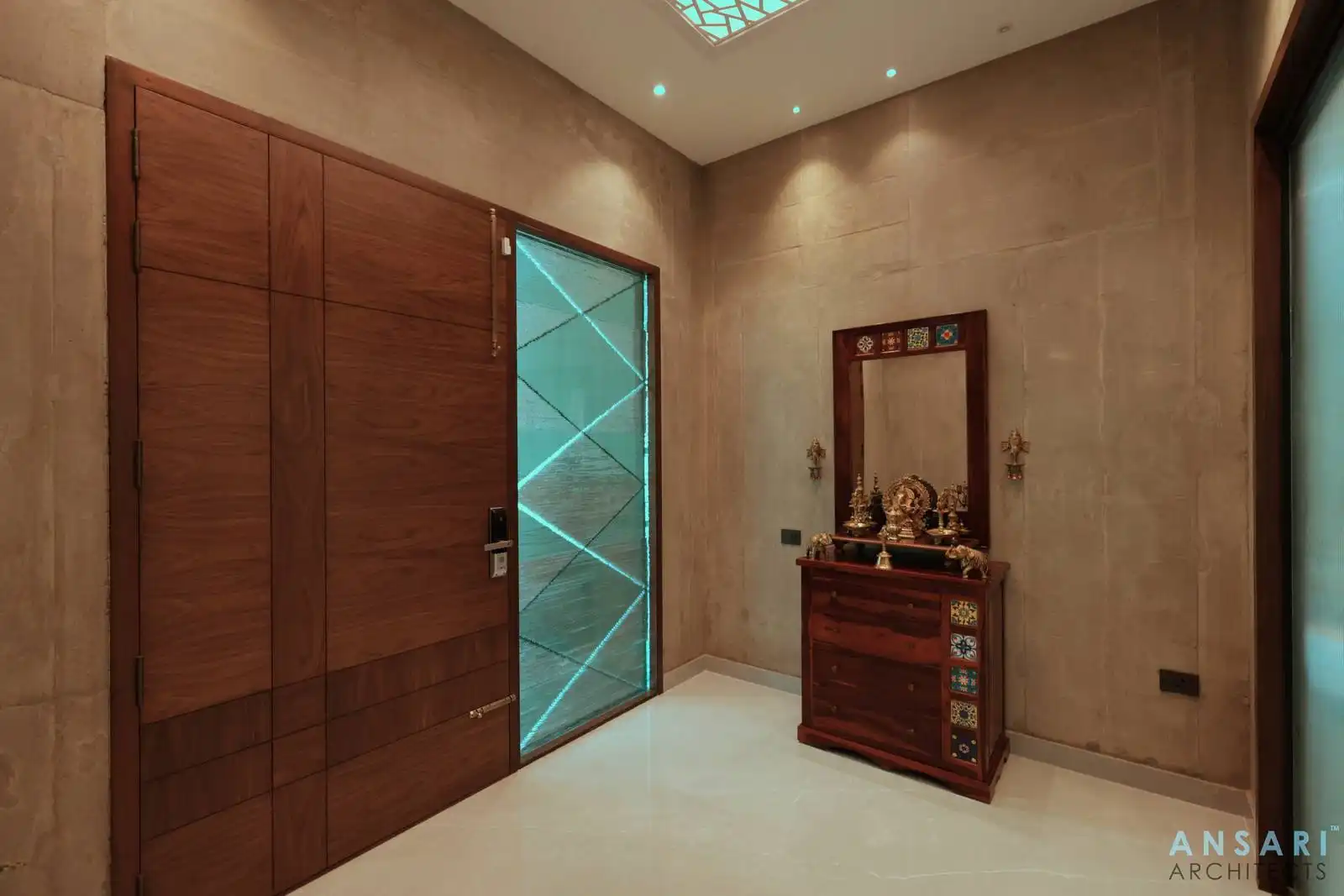 In the lobby area, a full-height glass panel with LED-lit geometric patterns beside the main door creates a striking, modern entry feature.