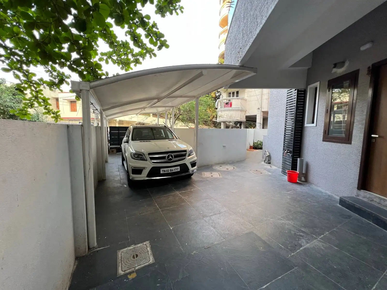 The parking area is located at the back side of the house, providing a private and secure space for vehicles. The area is bordered by a medium-height boundary wall, ensuring privacy and security while allowing some visibility and airflow.