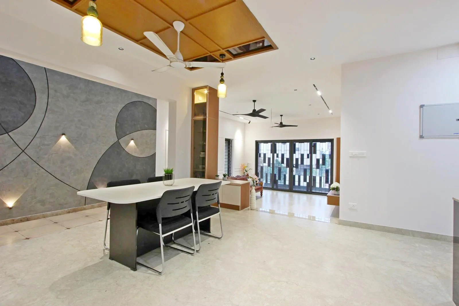 The open-plan layout unites the living, balcony, courtyard, and dining areas, creating seamless visual and physical flow. The balcony extends the living space outdoors, enhancing depth and providing a relaxing outdoor connection.