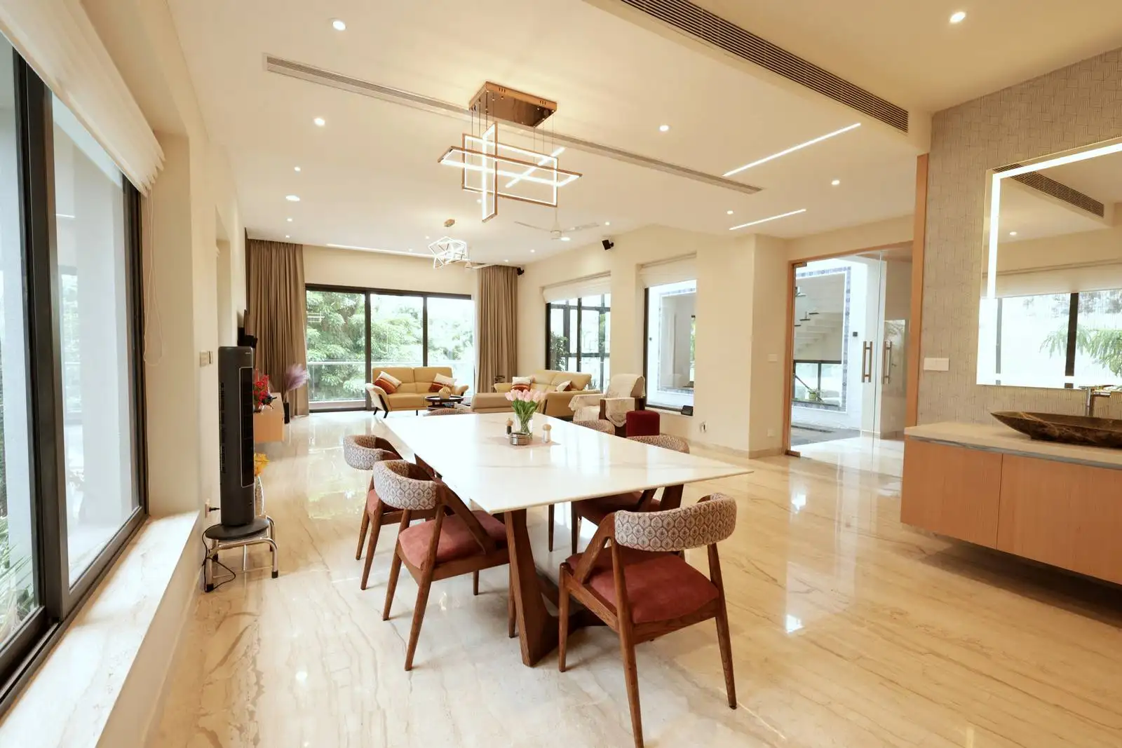 The dining area is centrally located within an open-plan layout, seamlessly connecting to the living room and adjacent spaces.
