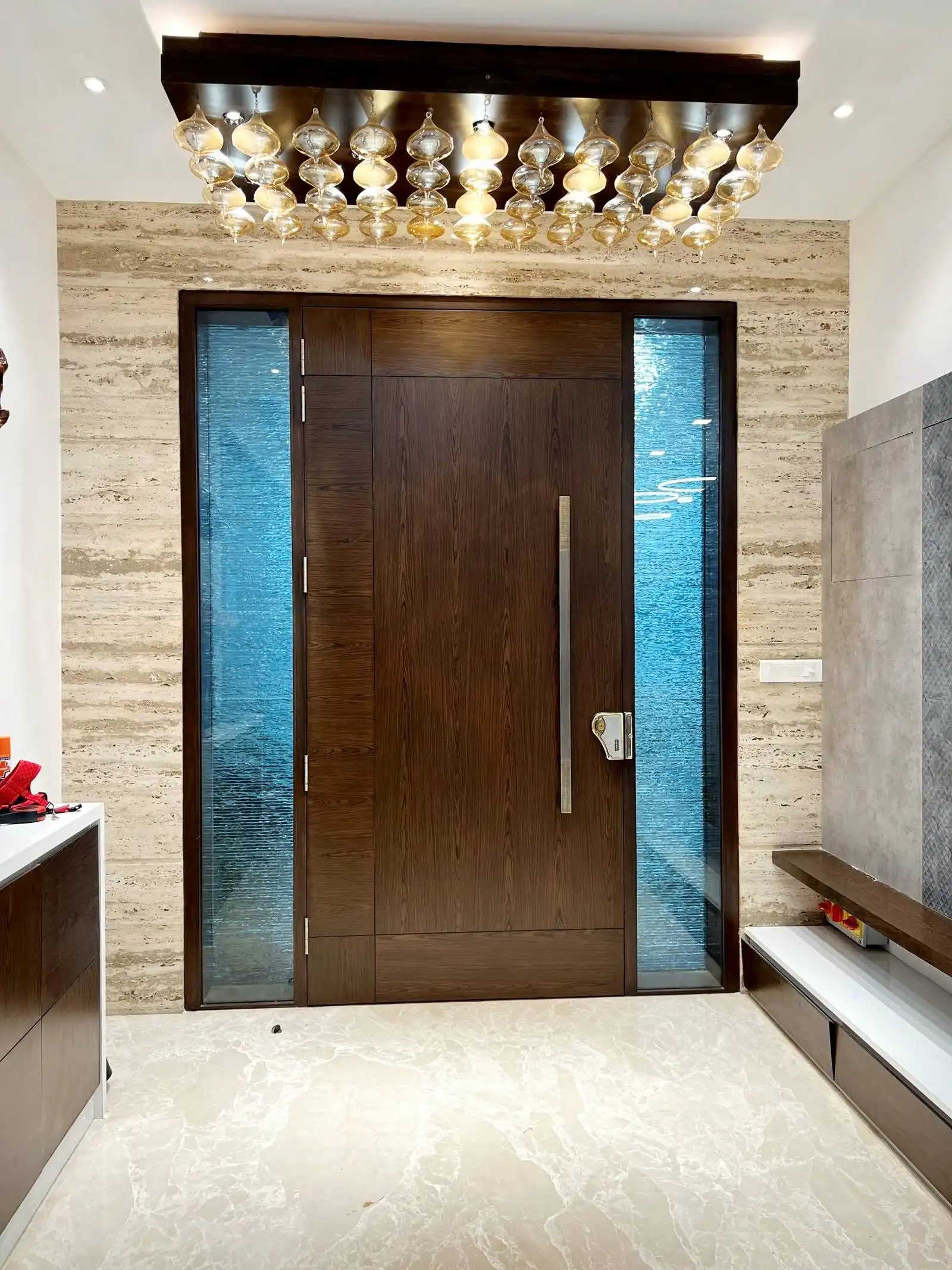 The door is flanked by vertical glass panels on both sides, allowing natural light to filter into the entryway while maintaining privacy with a textured.