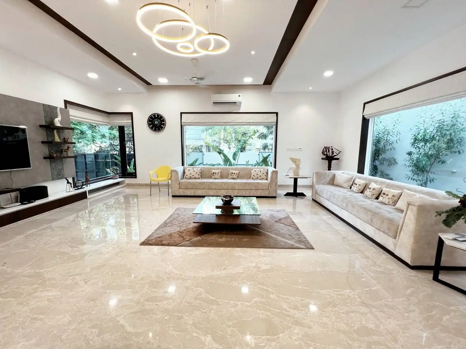 The seating arrangement features two plush, light-colored sofas facing each other, creating a cozy conversation zone centered around a modern coffee table.