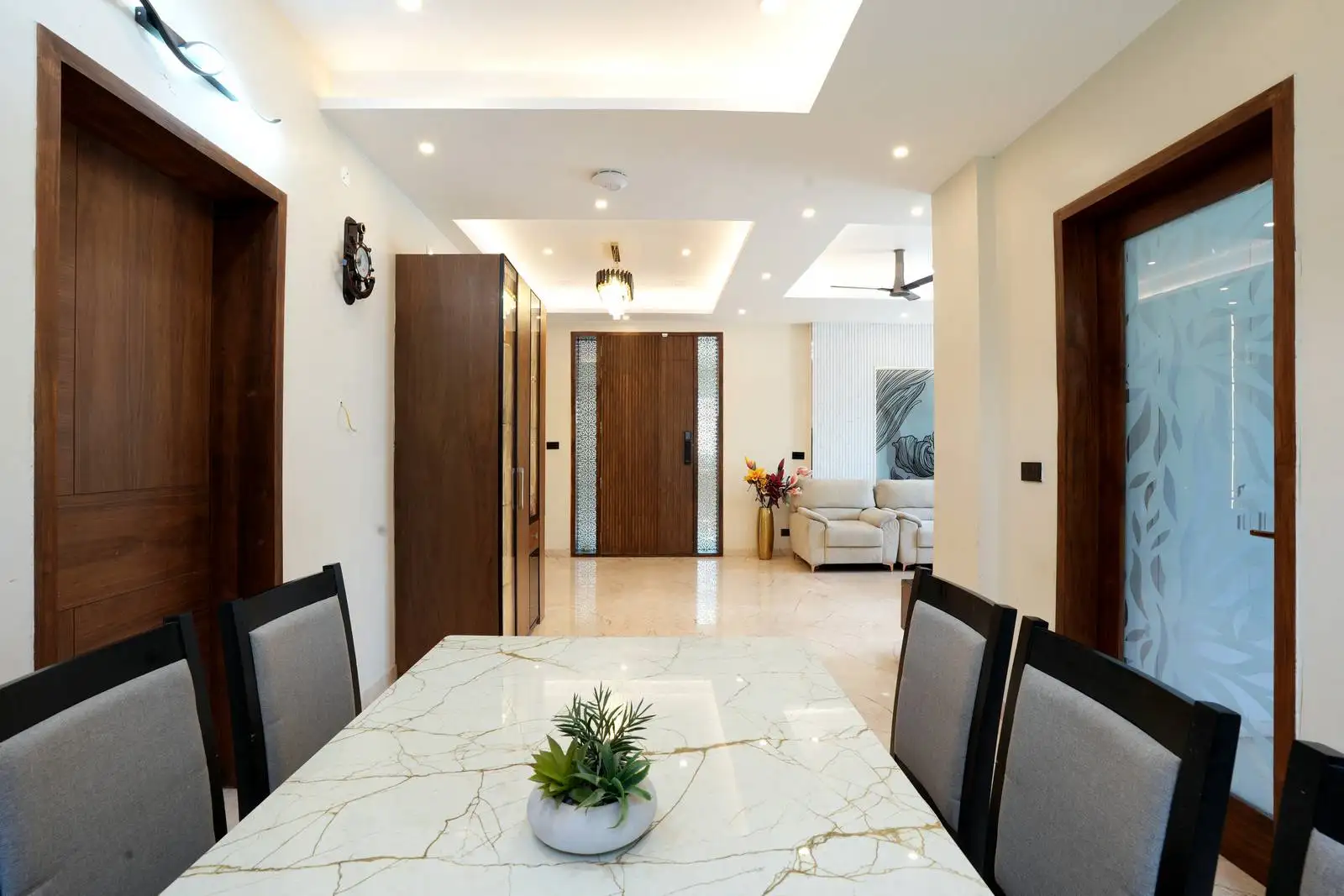 Open dining area seamlessly connects to the living room, featuring warm wood accents and recessed ceiling lighting for a cohesive, elegant feel.
