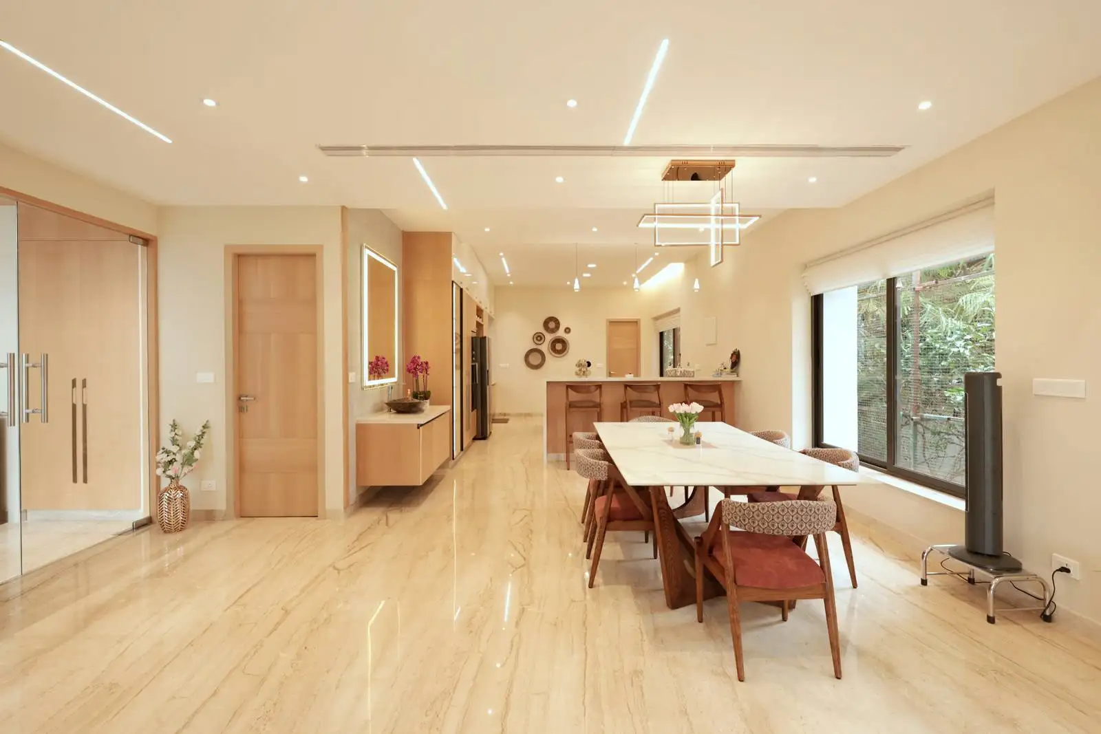 Large windows on one side bring in abundant natural light and offer views of greenery, enhancing the connection to the outdoors.