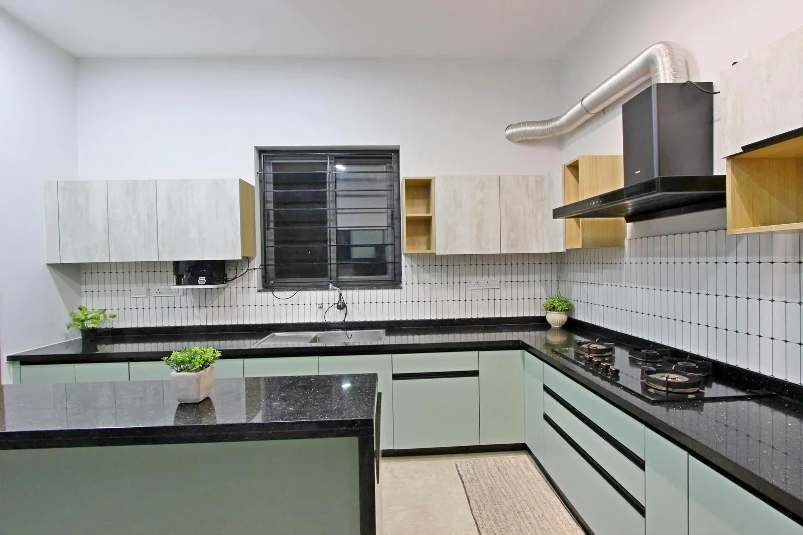 Pastel cabinets, black granite counters, and light wood accents create a bright, modern, and balanced look.