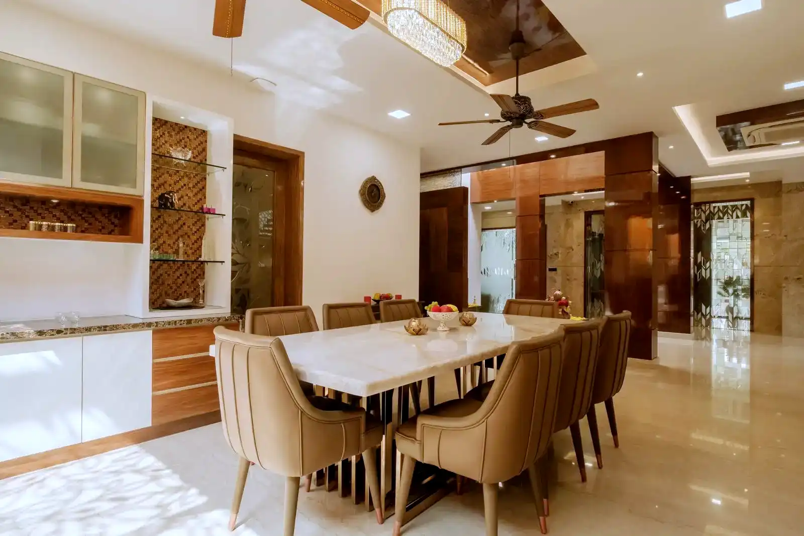 The dining room showcases a refined mix of marble, wood, and glass, enhanced by elegant lighting for a warm, sophisticated ambiance.