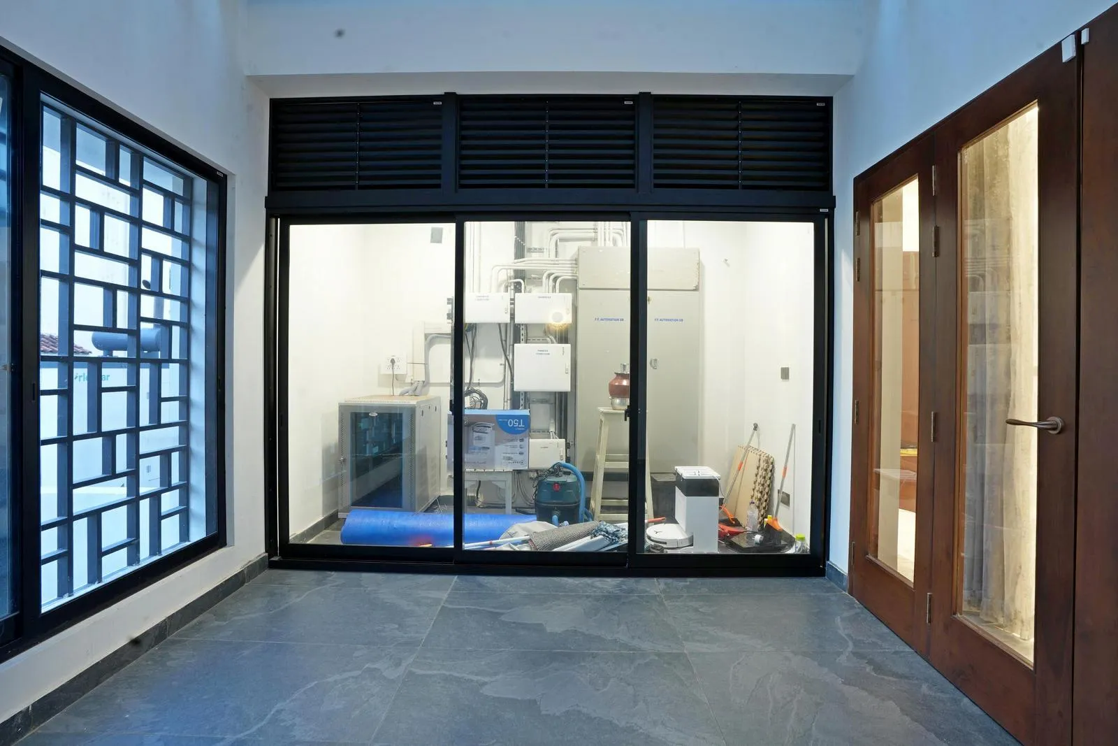 Houses essential systems like HVAC, water filtration, and electrical equipment. A folding glass door ensures easy access for maintenance while keeping the space discreet and organized.