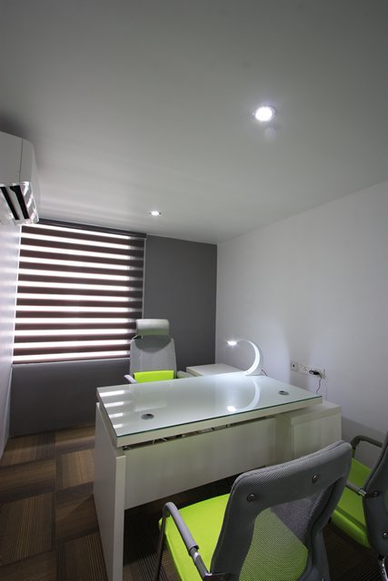 Contemporary workspace with layered lighting, a clean white desk, subtle accent wall, and integrated climate contro
