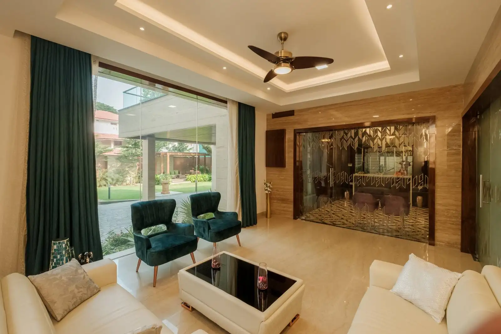 Reception area with an open, airy layout featuring polished marble flooring, balanced seating with white sofas and teal chairs, and large windows maximizing natural light and outdoor views.