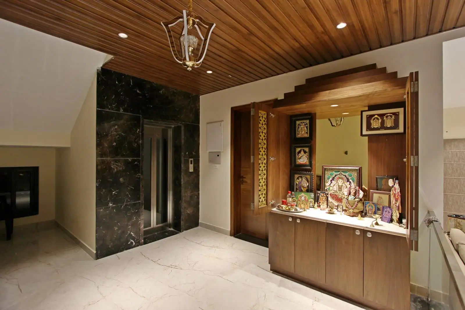 The puja room is elegantly integrated into the living space.Warm lighting inside the puja room enhances the spiritual ambiance.