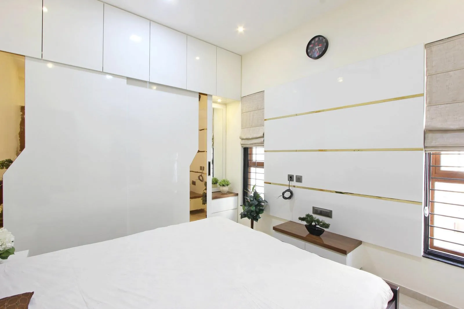 The bedroom has two symmetrical side windows that evenly illuminate the bed and study areas. Their alignment complements the linear wall panels and cabinetry, ensuring visual harmony and glare-free daylight for comfort and clarity.