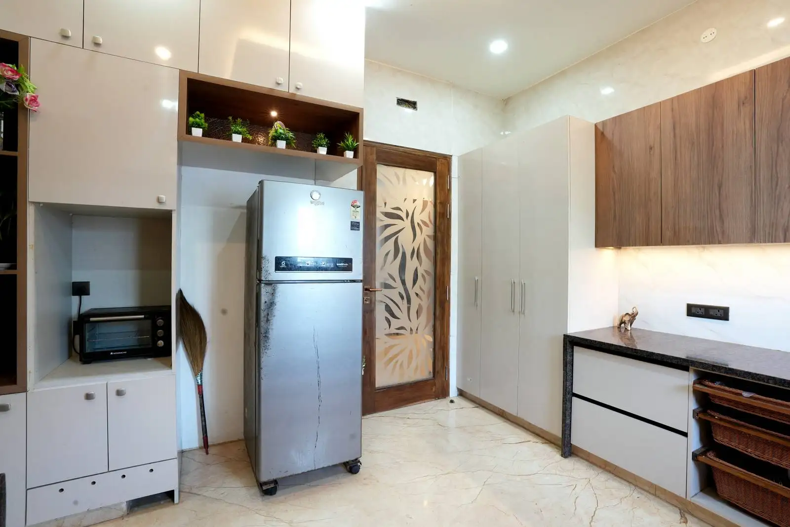 Showcasing design expertise, this kitchen combines efficiency and warmth through refined materials, clever storage, and integrated natural elements for a welcoming atmosphere.
