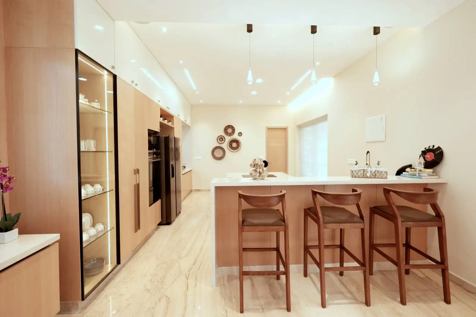 The dry kitchen is designed as an open, linear space with a central island that doubles as a breakfast bar. The layout promotes easy movement and interaction, ideal for casual dining and entertaining.