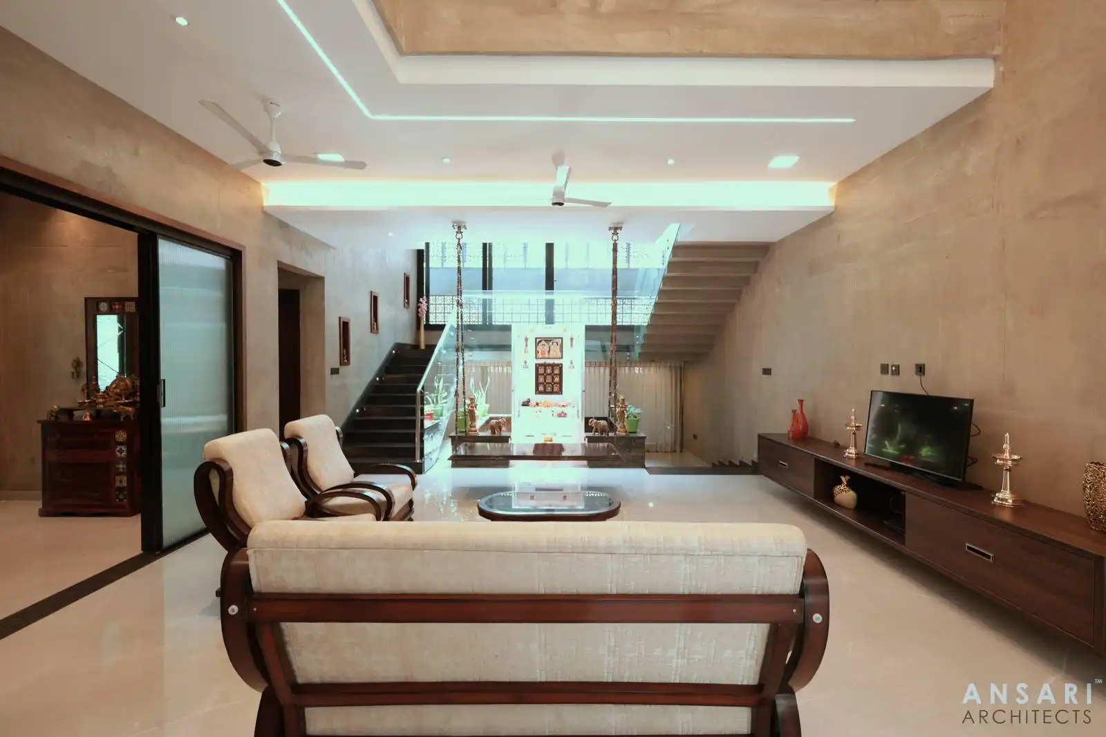 Open living room with spacious flow, neutral tones, and glass staircase for a modern, comfortable feel.