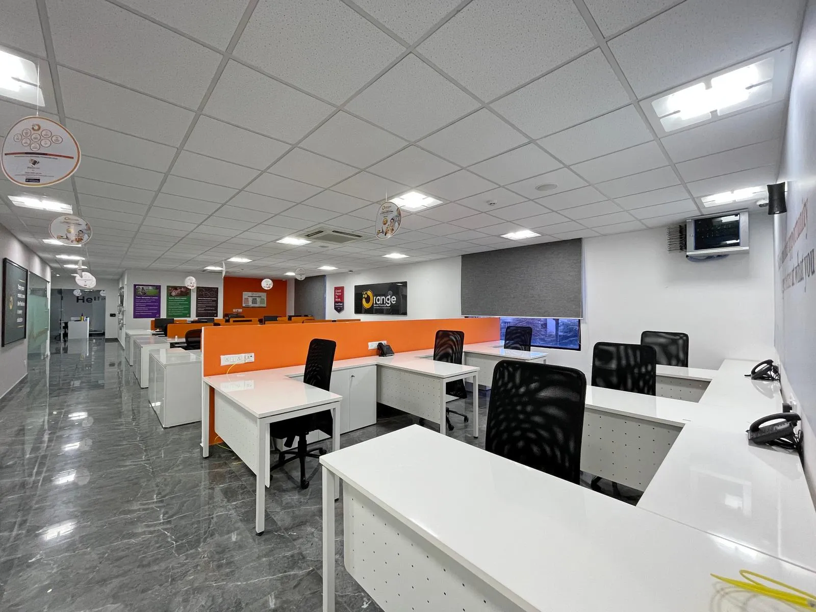 The Function Heads’ cubicle area features six semi-private workstations with orange accents, ergonomic furniture, and frosted glass partitions for focused, collaborative work. Grey marble flooring, acoustic ceilings, and clean finishes enhance spatial depth, comfort, and a professional corporate aesthetic.