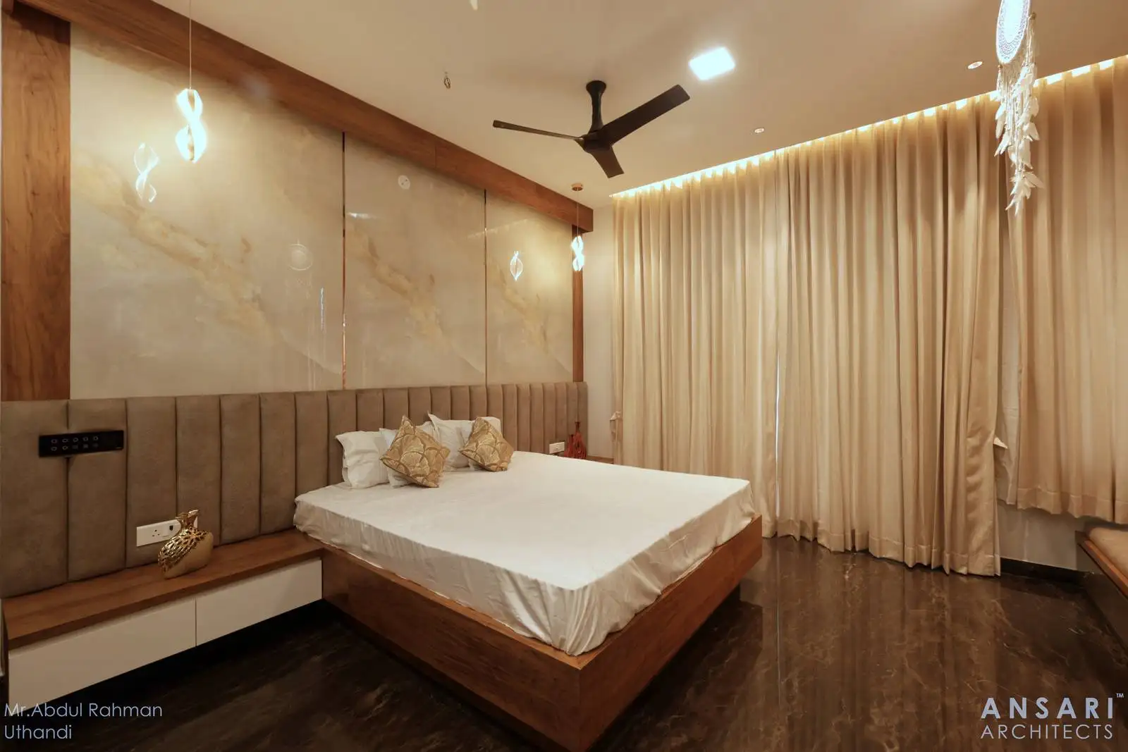 The headboard wall is a focal point, featuring marble panels framed with warm wood, adding both luxury and texture.