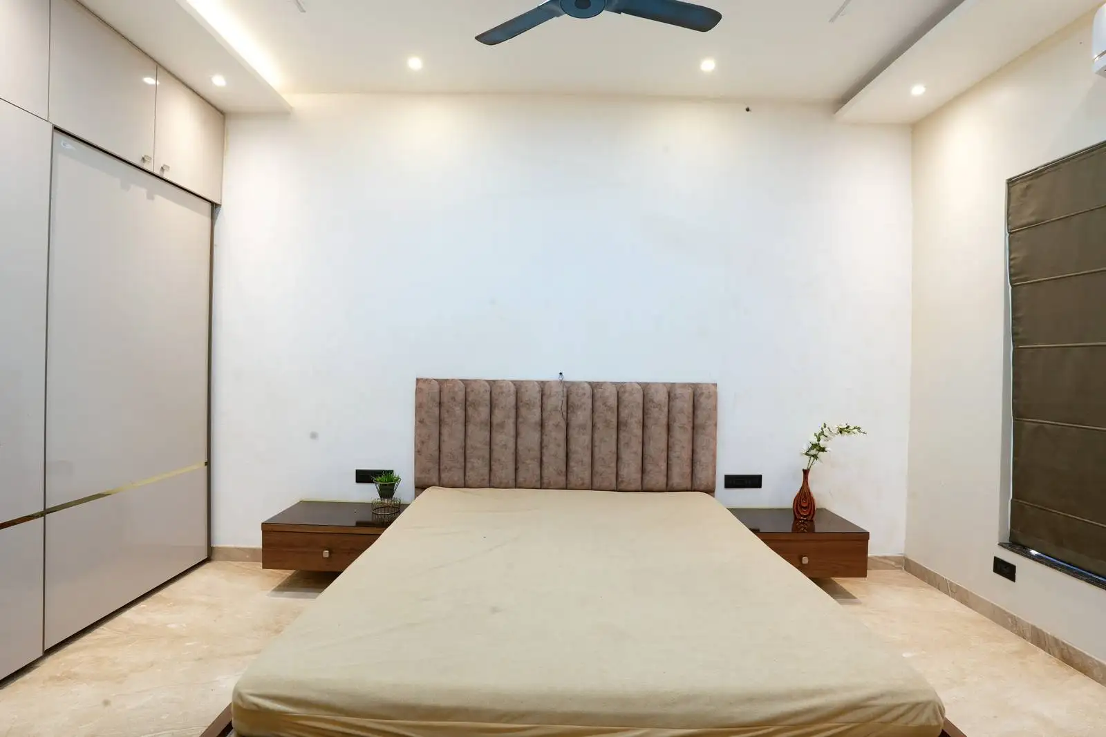 Designed with thoughtful detailing, the bedroom integrates upholstered headboards, handle-less wardrobes, and floating nightstands to create a serene, functional space.