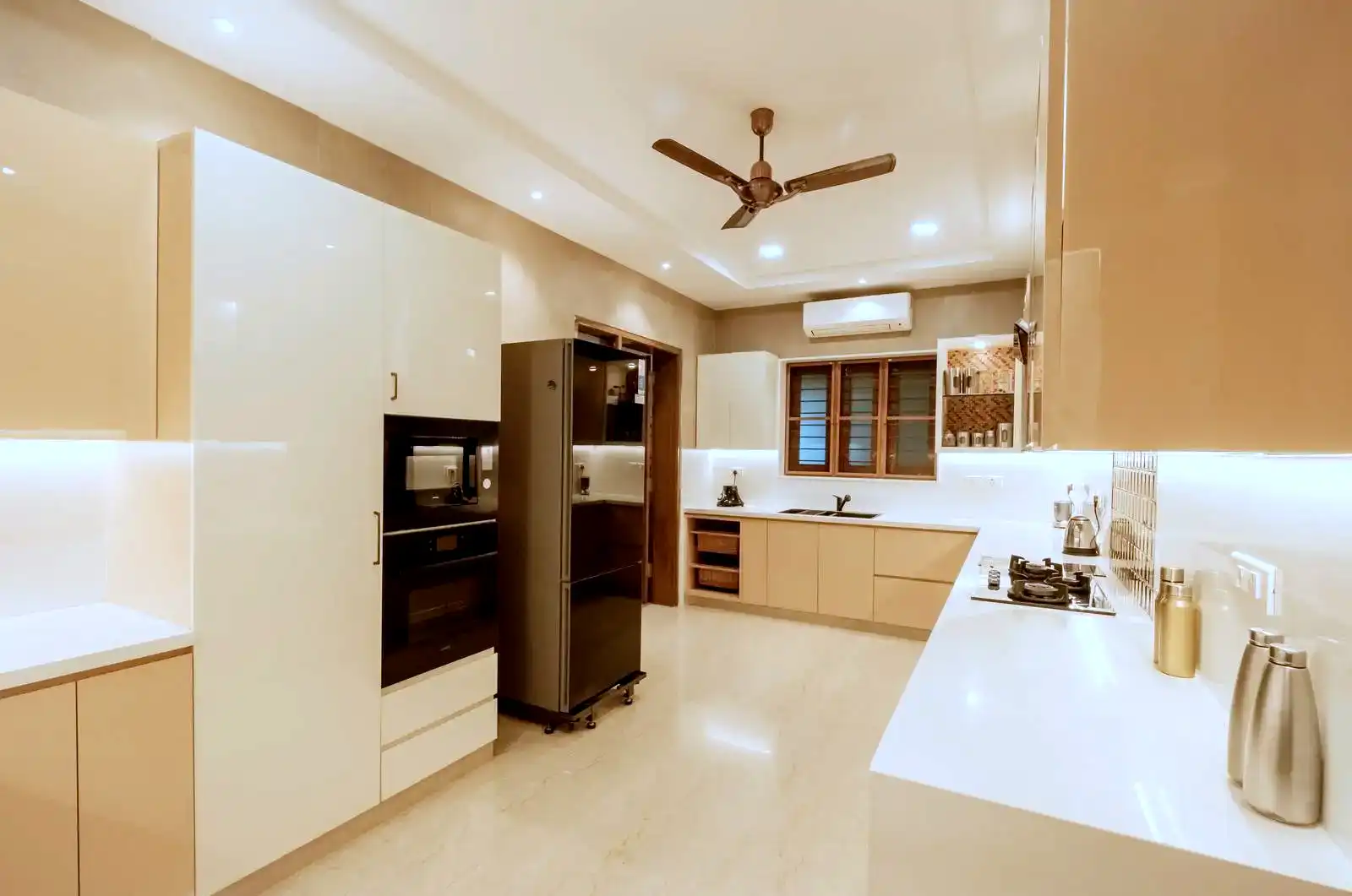 The kitchen includes a large window for natural ventilation, seamlessly integrated modern appliances, and an air conditioning unit for added comfort during cooking.