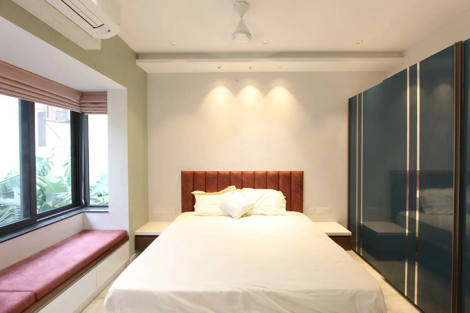 The bedroom features a glossy sliding-door wardrobe and built-in nightstands for streamlined storage. 