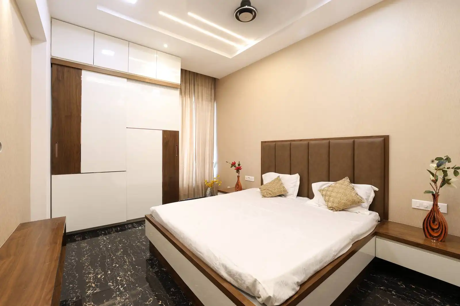 The bedroom emphasizes openness and functionality, with a central layout, built-in floor-to-ceiling wardrobe, and a window that fills the space with natural light.