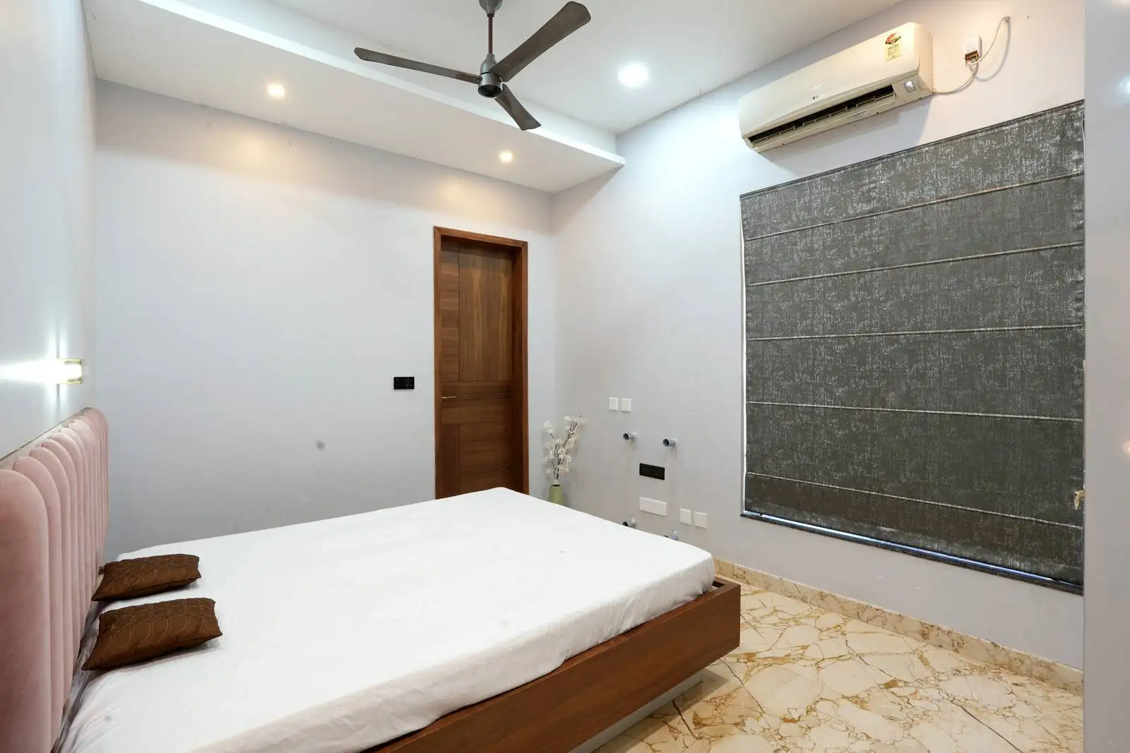The large window is covered with dark, textured blinds, offering privacy and effective light control. This also helps regulate temperature and ambiance.