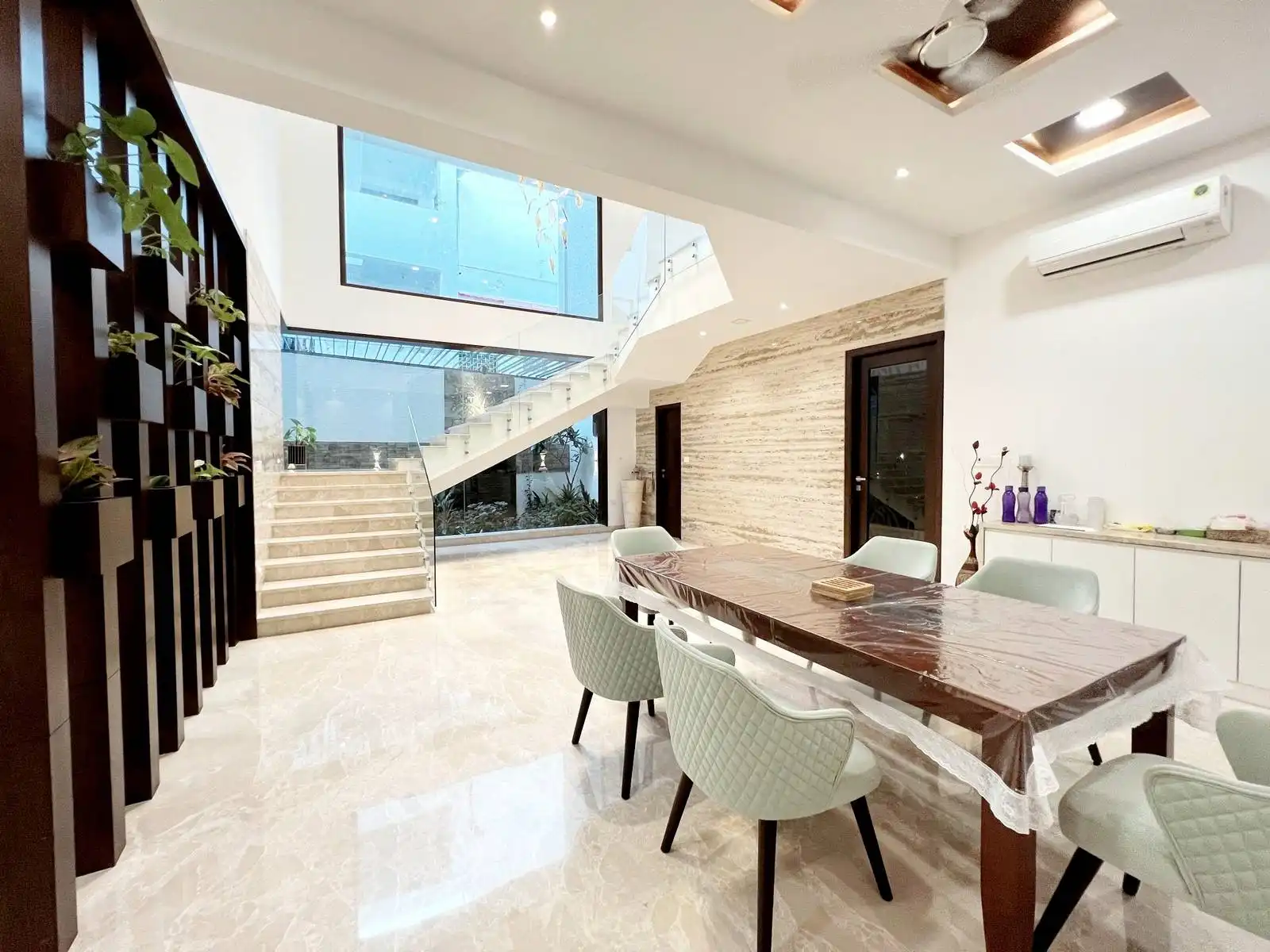 A large, rectangular window is positioned at the first-floor level, directly above the staircase.
The window brings in abundant natural light, illuminating both the staircase and the dining area below.