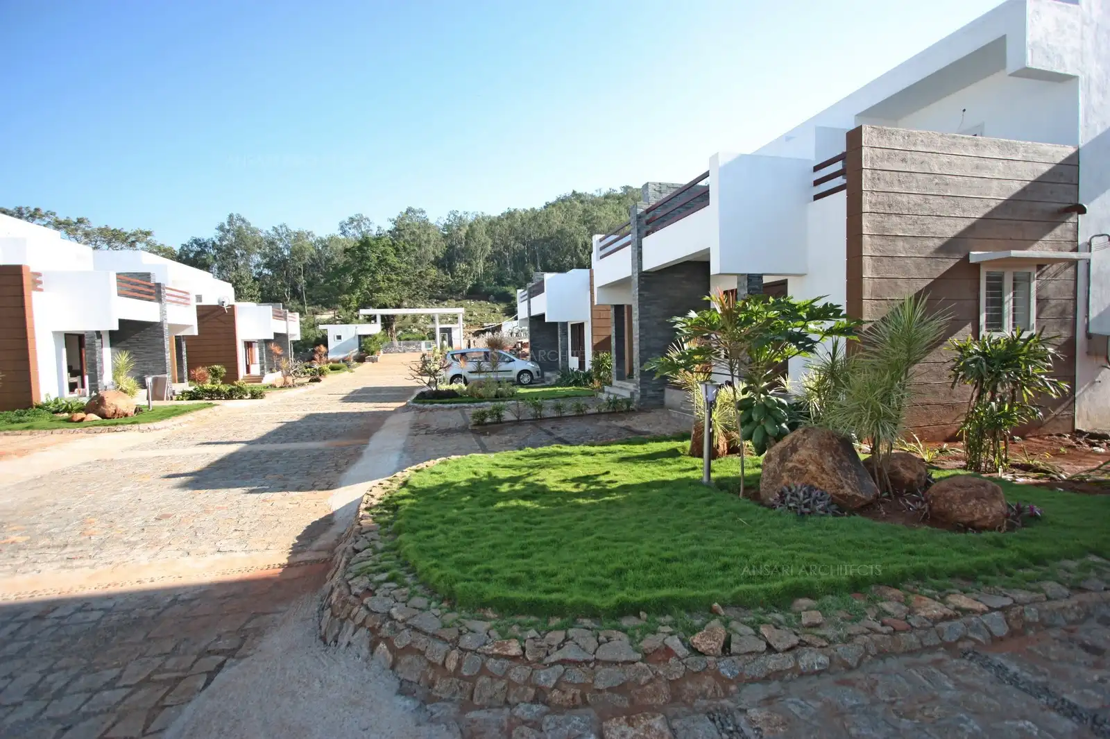Lush landscaped gardens with water features and shaded seating areas create a serene, elegant outdoor environment for relaxation and gatherings.