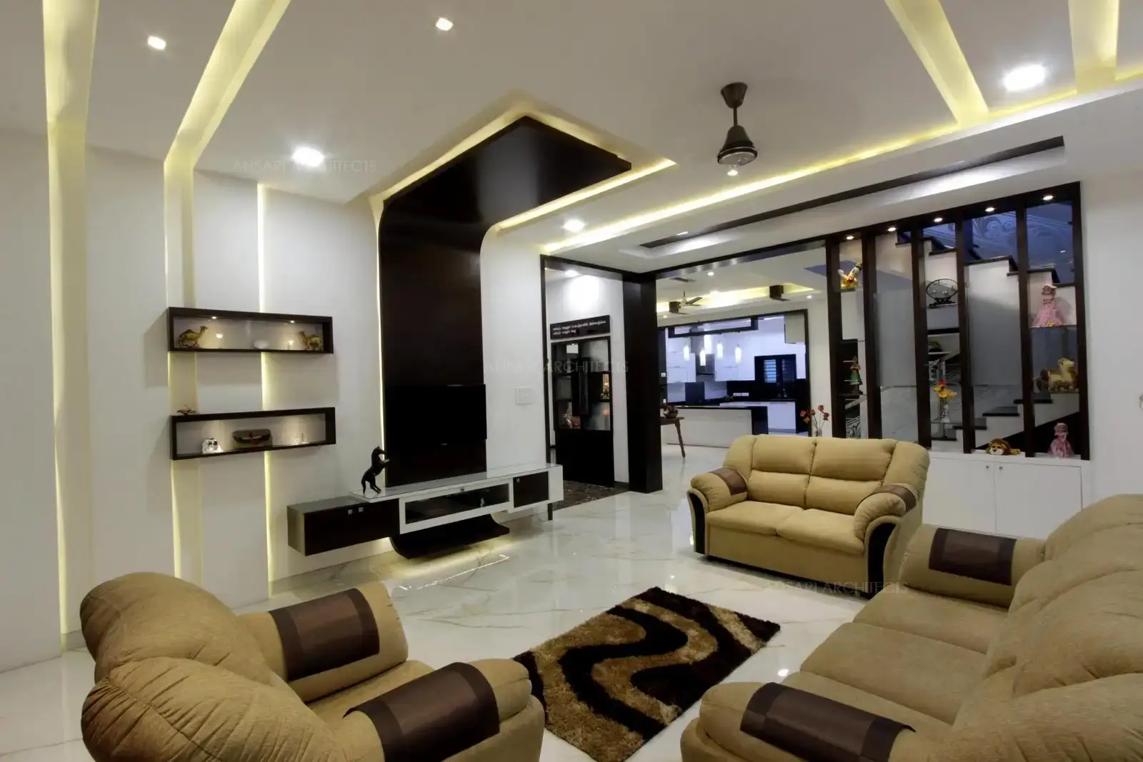 An innovative approach of design here, with sleek TV unit, cushioned seaters with off white seaters, the rug , the battened partition gives the quality of luxury here.
