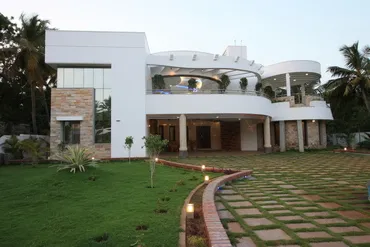 a large white house with a lawn and a walkway