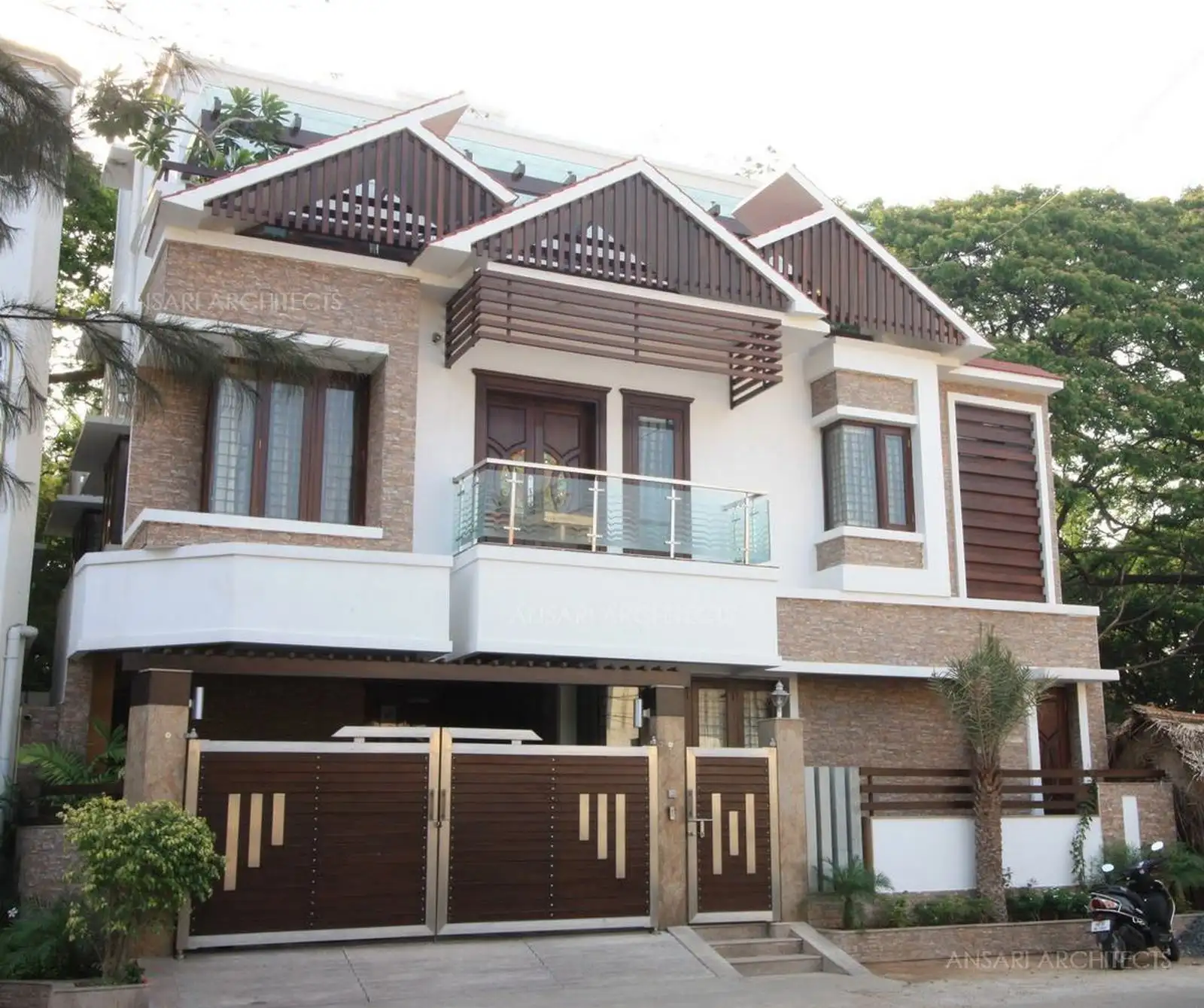 Exterior architecture of the house has been finished with rustic stone cladding and wood with slope roofs at the second floor level.
