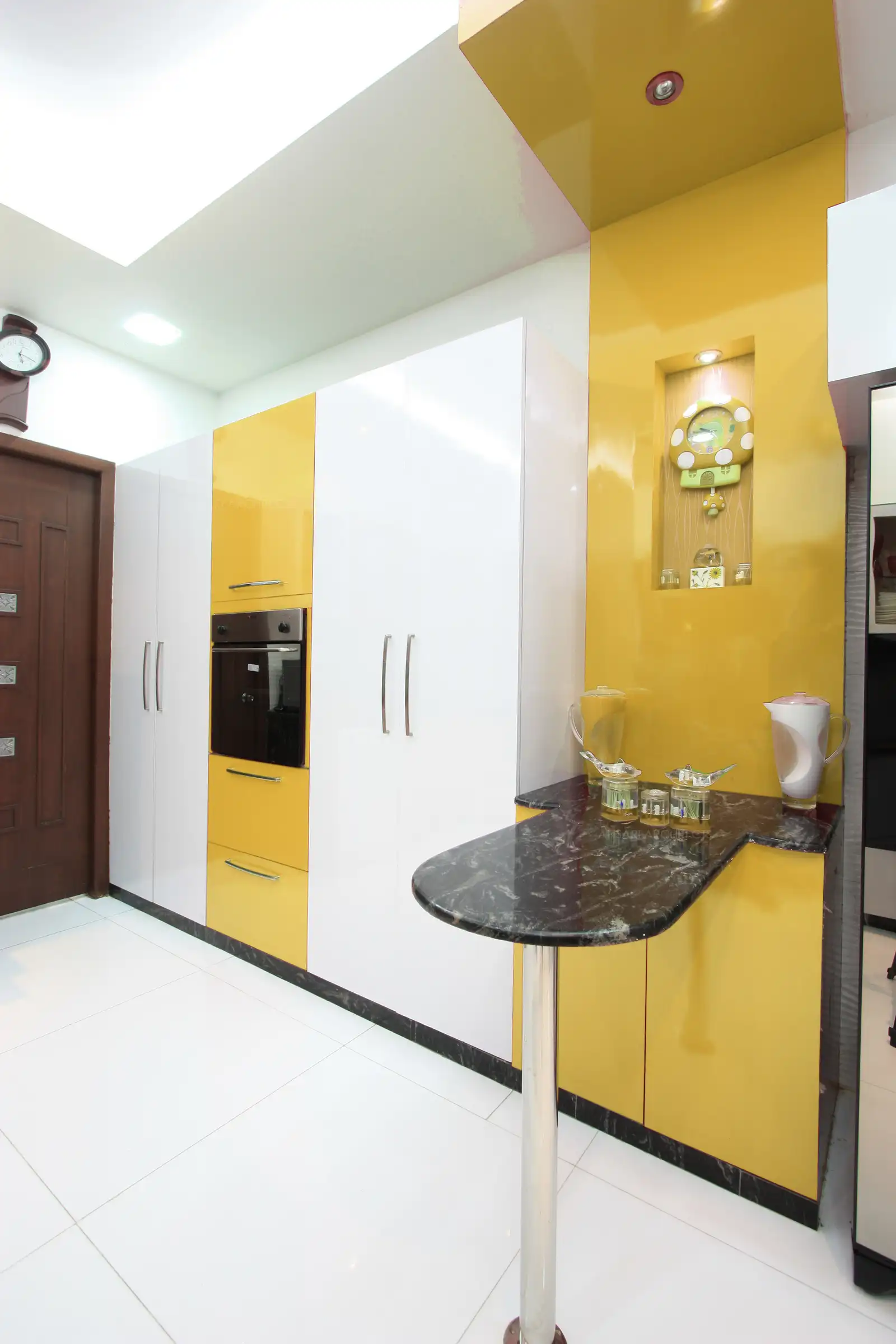 Kitchen designed with full height cabinets and built in oven helps in better storage and mobility within the area.