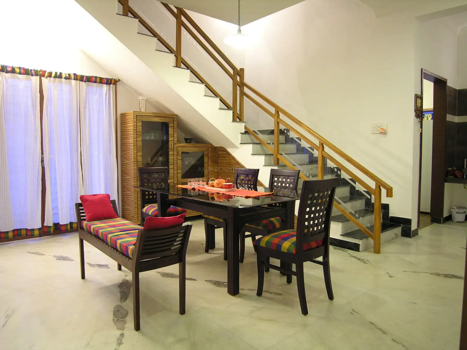 Dining table was specifically selected to match with the veneers used in the interiors with bright multi colour furnishings.