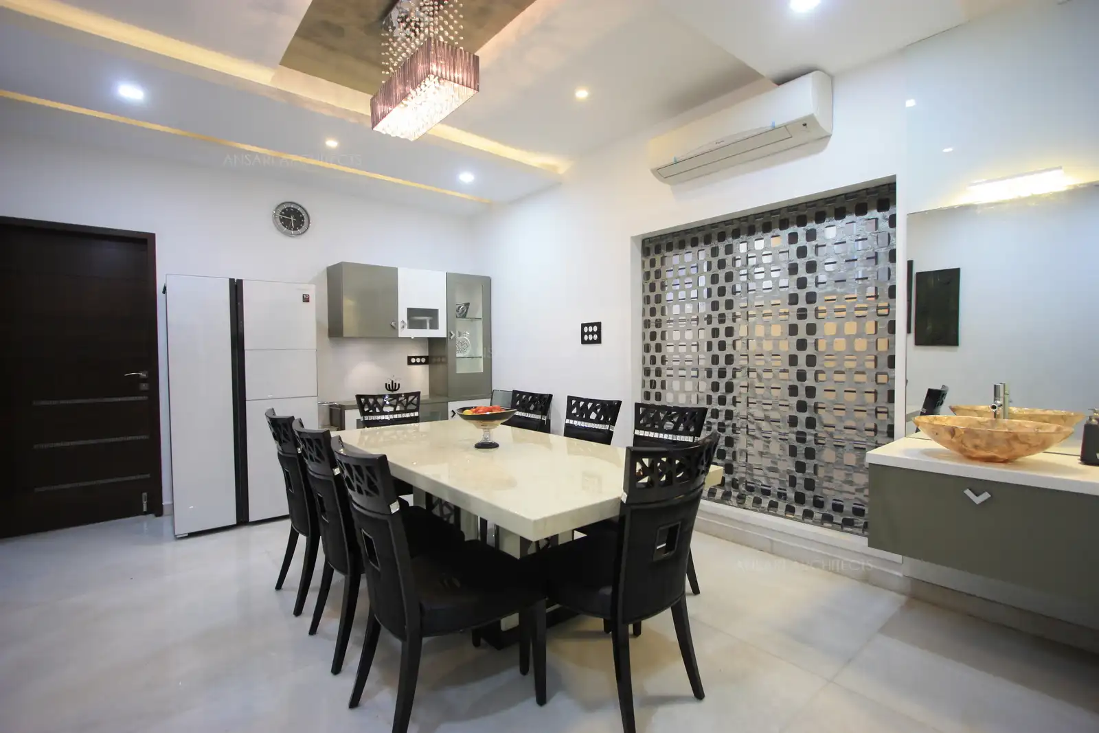 Neutral colour scheme of white grey and black lights up the dining area well.