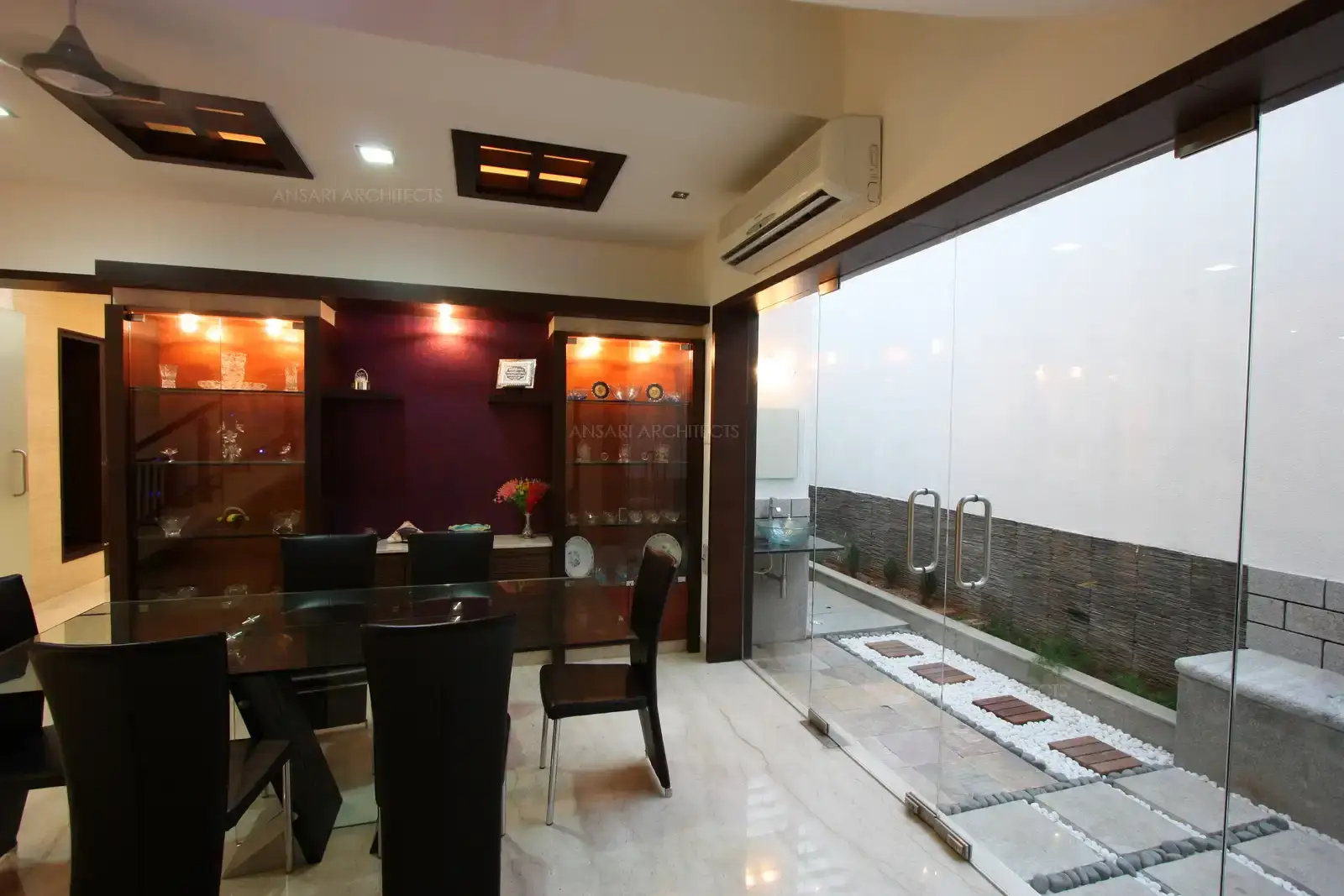 Dining room opens up to the courtyard area with clear glass doors and partition.