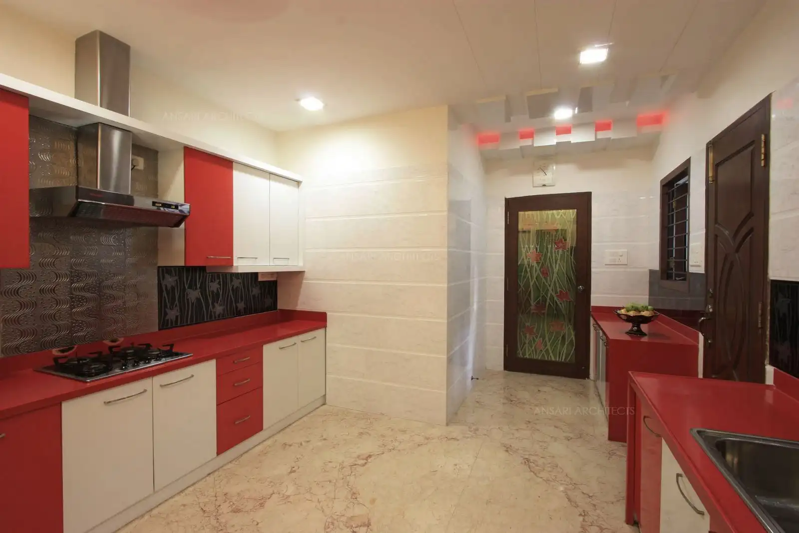'Corian' counter top and full height glossy wall tiles are given all around the kitchen for easy maintenance.