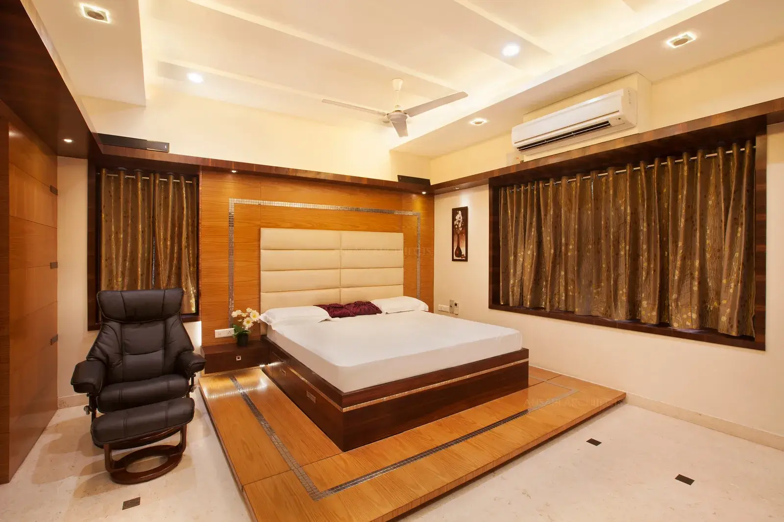 Master bedroom with raised wooden platform and high backrest for a royal and comfortable feel.