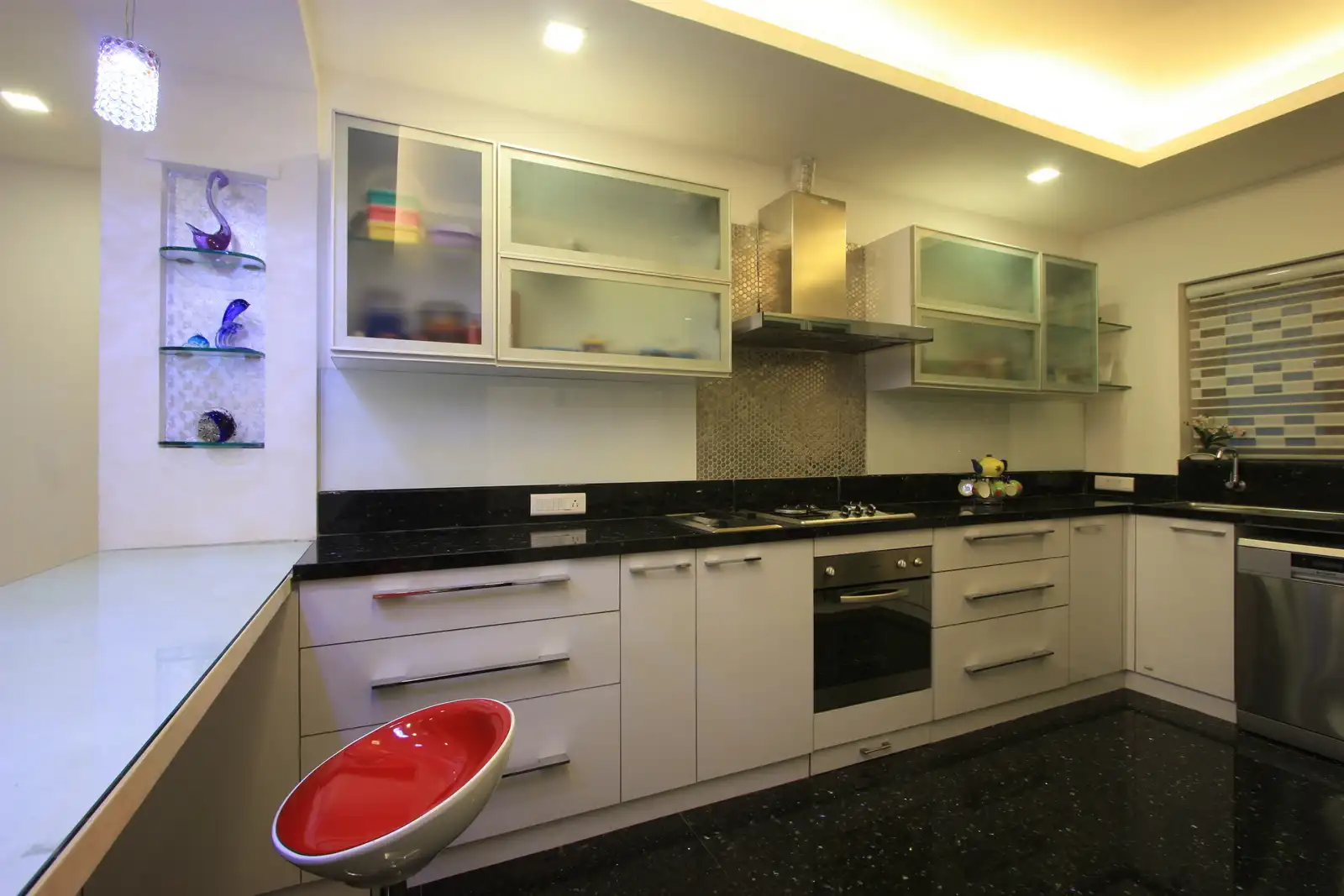Kitchen has been designed in simple black and white colour scheme with silver highlights.