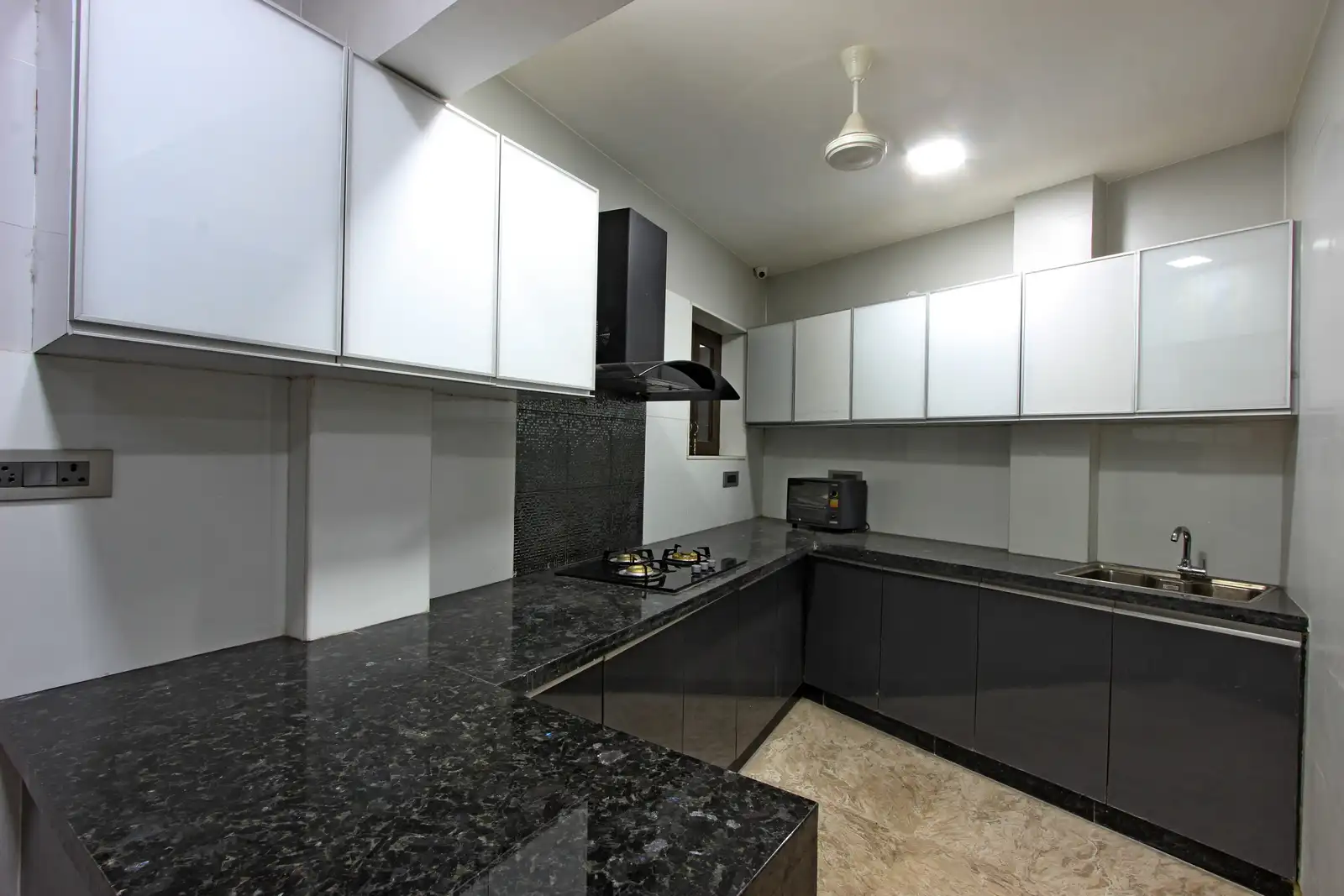 The fully equipped modular kitchen shares optimal space with granite top counters in neutral scheme.