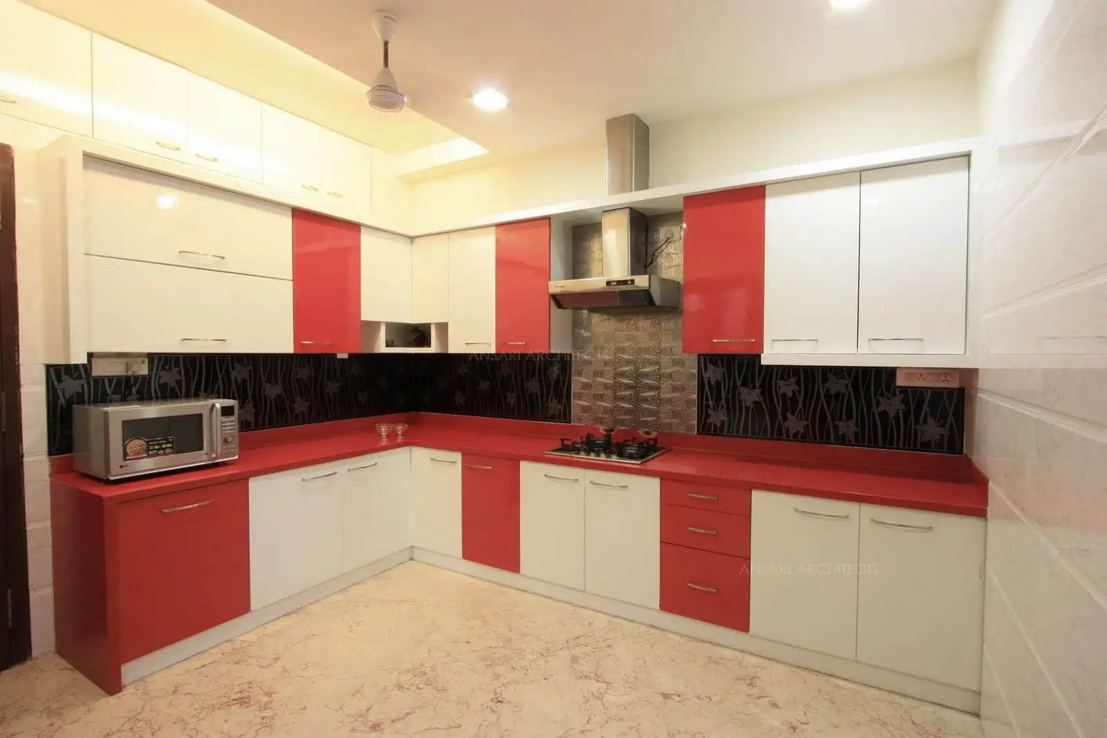 Kitchen has been designed with white and red colour scheme giving it vibrant look.
