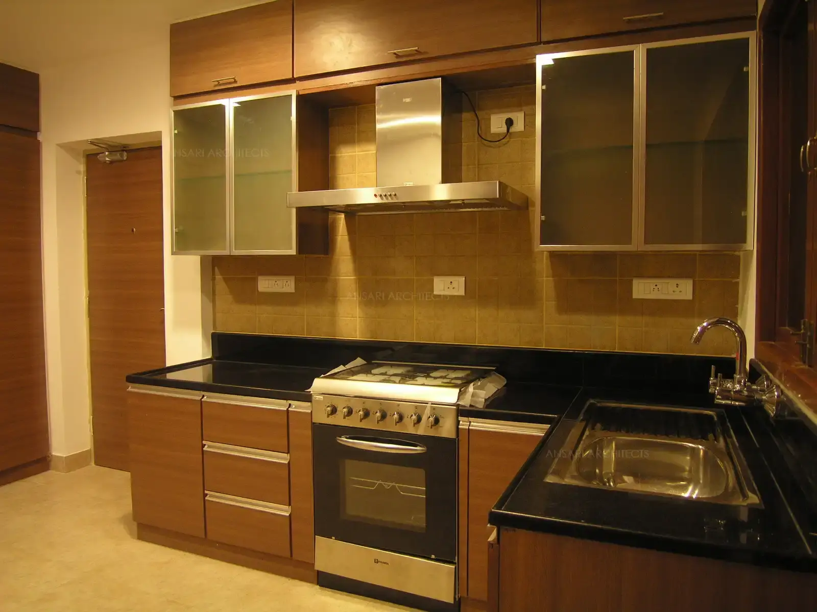 Kitchen has been designed in simple and clean wooden finish with stainless steel highlights.