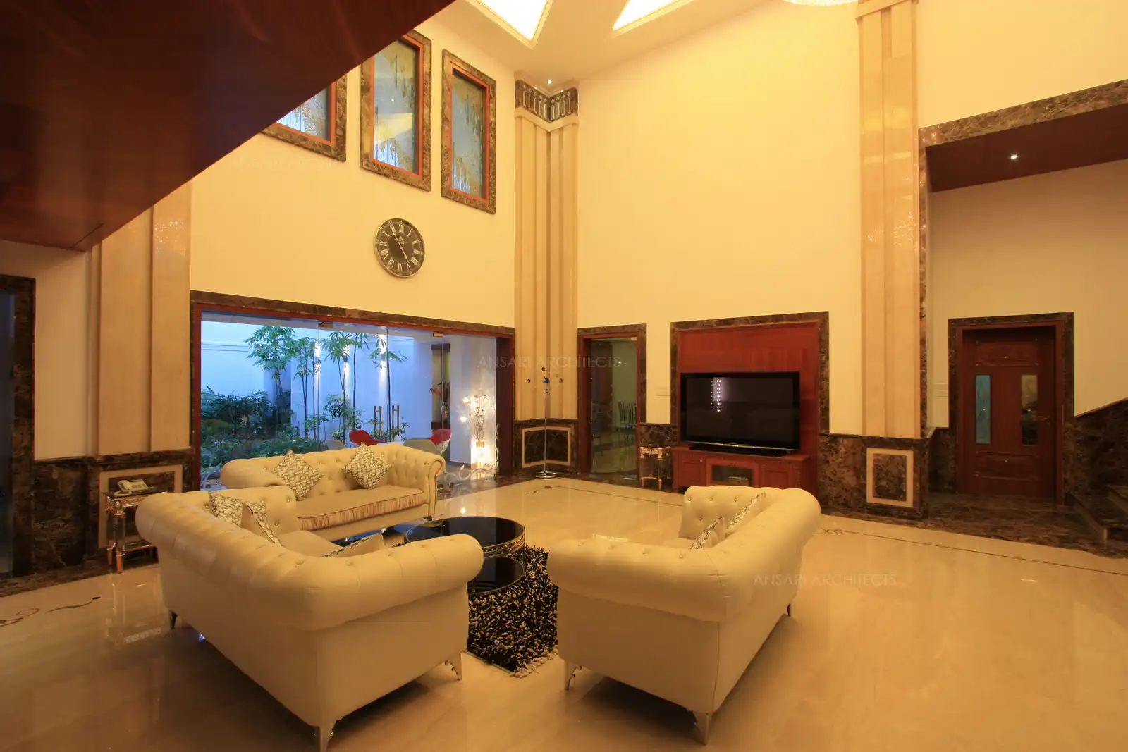 View of living room showing the courtyard through clear glass doors.
